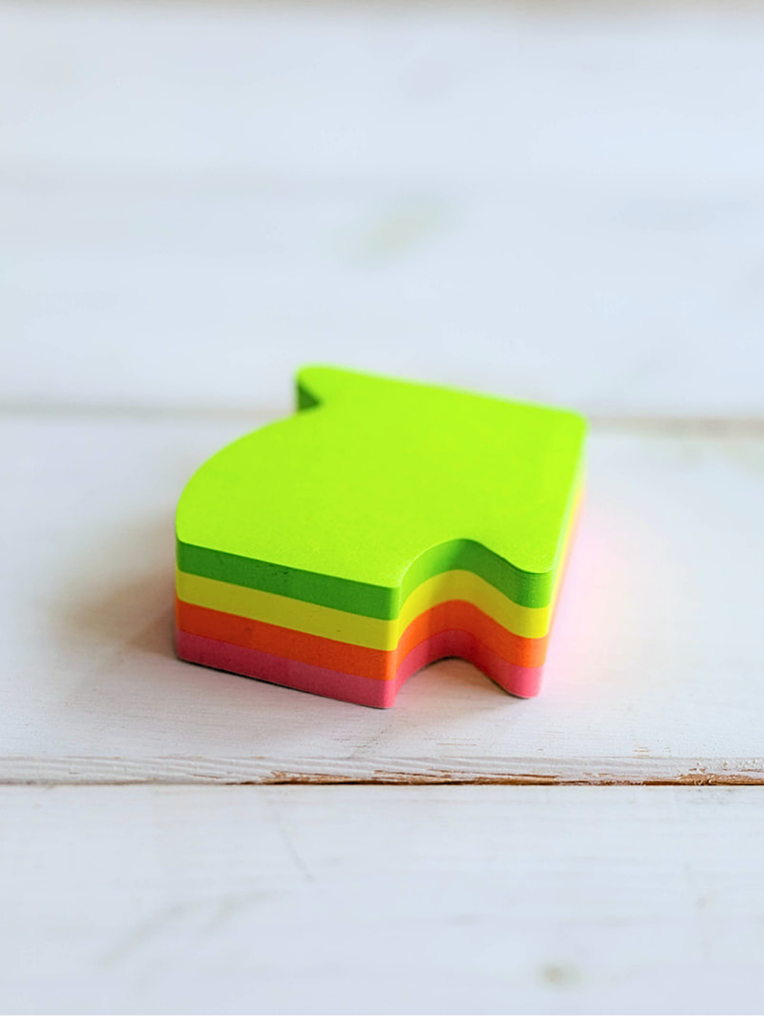 Strategie und Transformation Block bunter Post-its in Pfeilform auf neutralem Hintergrund, Symbol für strategische Ausrichtung